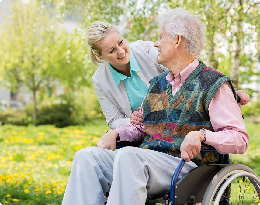 Elderly man in wheelchair with caregiver